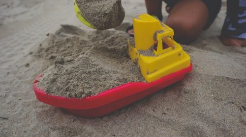 sand tray therapy - sand in boat like tray that kids are playing with in the sand. Sand tray therapies supports healing through play and imagination can take place.